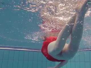 Rood geklede tiener zwemmen met haar ogen opened