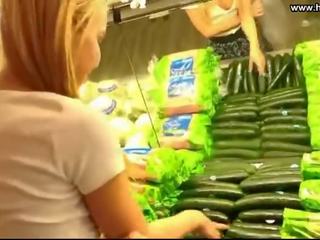 Joven mujer folla pepino en público supermarket